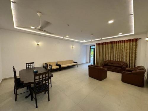a living room with a table and chairs and a couch at Colombo Reach Appartment By Layathraa in Kaduwela