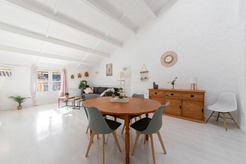 - un salon blanc avec une table et des chaises en bois dans l'établissement Le Verdon - Superbe appt vue montagne, à Riez