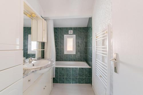 a bathroom with a bath tub and a sink at Le Verdon - Superbe appt vue montagne in Riez