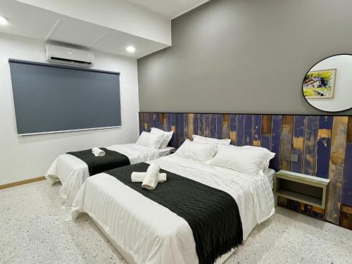 two beds in a room with a projection screen at Traveler's Stay @ Ipoh (10Pax) in Ipoh