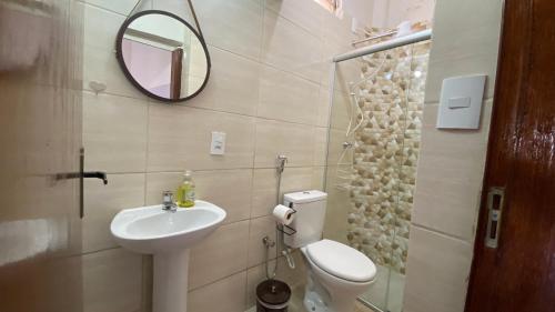 a bathroom with a sink and a toilet and a mirror at Kitnet recanto do mosteiro in Ribeirão Preto