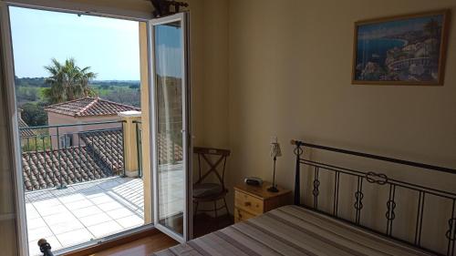 - une chambre avec un balcon doté d'un lit et d'une porte coulissante en verre dans l'établissement Villa Pays d'Oc, à Béziers
