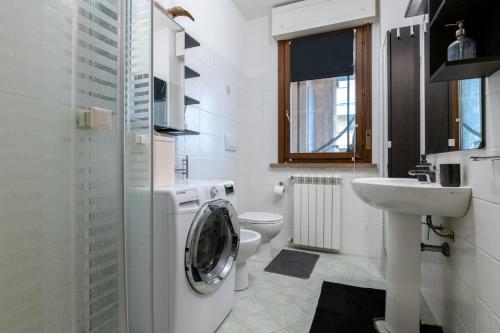bagno bianco con lavatrice e lavandino di Relax e Comfort in Zona Strategica per Visitare Pisa e Toscana a Pisa