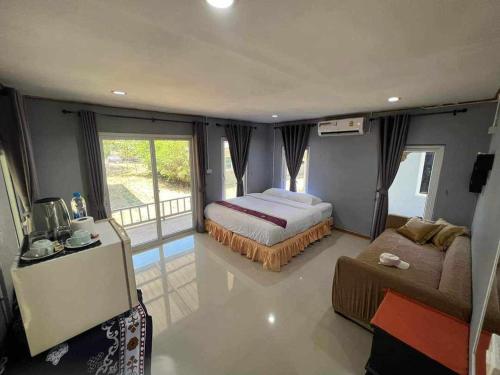 family resort في كو فايام: غرفة نوم فيها سرير واريكة