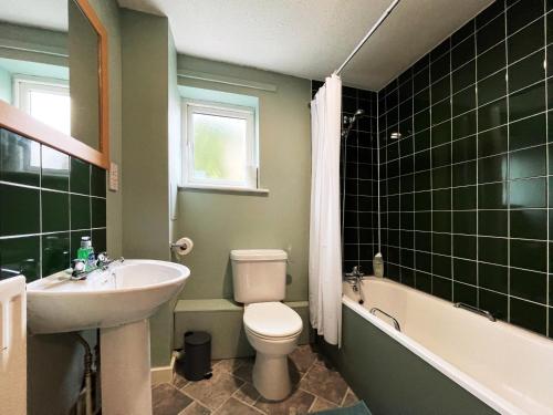 a bathroom with a sink and a toilet and a bath tub at Rebecca's Place at Whitechapel in London
