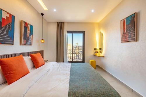 1 dormitorio con 1 cama con almohadas de color naranja y ventana en RA 35 by Majestic Properties, en Marrakech