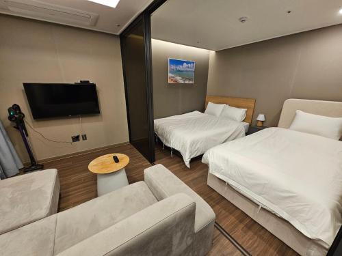 a hotel room with two beds and a couch at Gunamro Hotplace 3min Haeundae beach in Busan