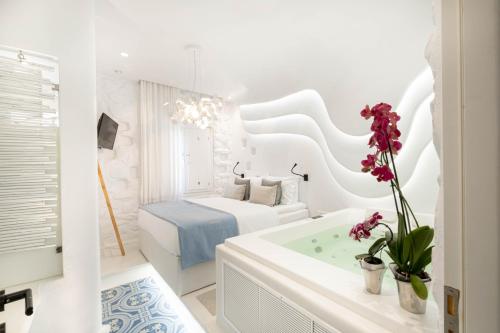 a white bathroom with a bed and a bath tub at KYMA & HELIOS Deluxe Suites with Hot Tub at AmazeU Suites Naxos in Naxos Chora