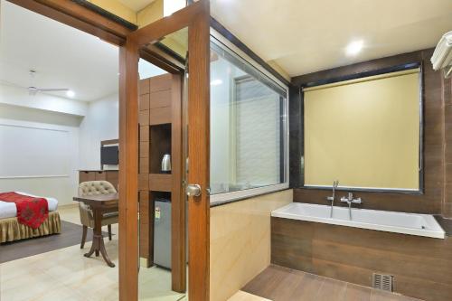 1 dormitorio y baño con bañera y lavamanos. en Hotel Hari Piorko Grand - New Delhi Railway Station en Nueva Delhi