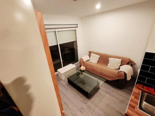 ein Wohnzimmer mit einem Sofa und einem Couchtisch in der Unterkunft STUDIO COSY PROCHE AEROPORT CDG in Arnouville-lès-Gonesse