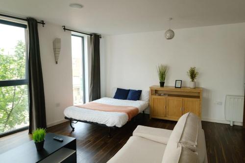 a living room with a bed and a couch at Modern 2 Bed Flat in East London in London