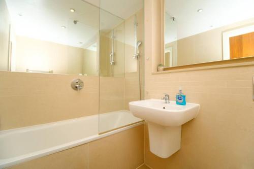 a bathroom with a sink and a shower and a mirror at Modern 2 Bed Flat in East London in London