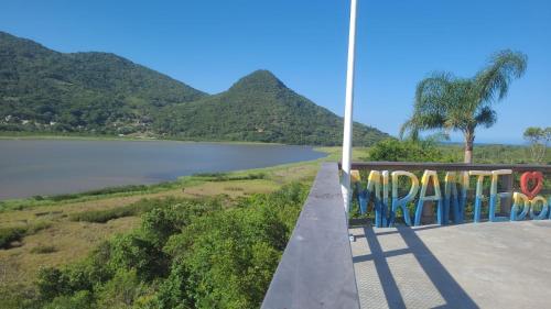 a view of a lake with mountains in the background at Suítes Costa Do Macacu-Garopaba in Garopaba
