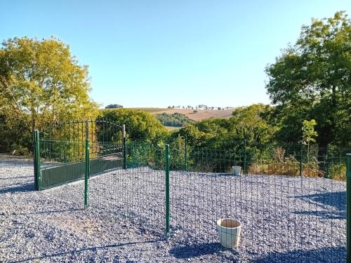 a chain link fence with a trash can in the middle at ROUPILLON A JANET in Curvalle
