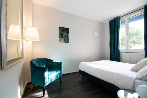 Habitación de hotel con cama y silla azul en Suite Madison, en Villeurbanne