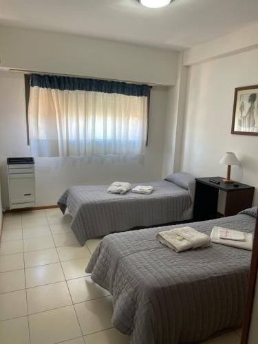 a hotel room with two beds and a window at Riazor Sol y Arena in San Clemente del Tuyú