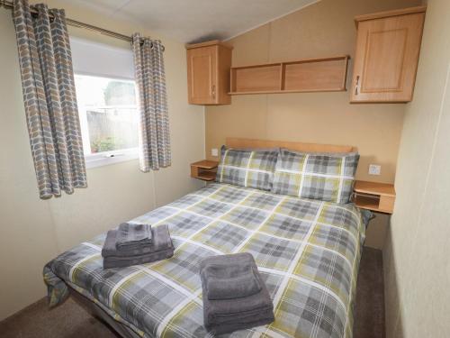 a bedroom with a bed with two towels on it at Berwyn View Holiday Home in Corwen