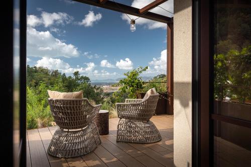two wicker chairs sitting on a balcony with a view at Tenuta Zamparina in Montignoso
