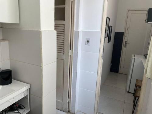 una cucina con pareti bianche e una porta che conduce a un corridoio di Loft funcional a Rio de Janeiro