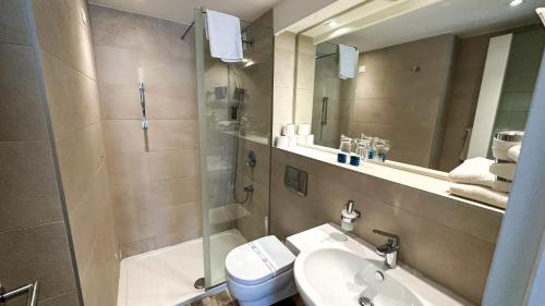 ein Bad mit einer Dusche, einem Waschbecken und einem WC in der Unterkunft Hotel Castellastva in Petrovac na Moru