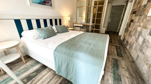 a bedroom with a large bed and a chair at Hotel Castellastva in Petrovac na Moru