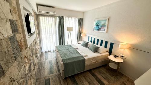 a hotel room with a bed and a television at Hotel Castellastva in Petrovac na Moru