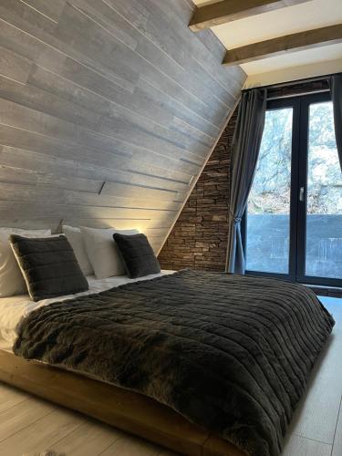 a bedroom with a large bed with a wooden ceiling at Valea Mosului - Cozy A Frame in Petroşani
