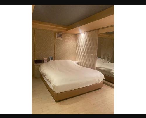 市原市にあるラフォーレのベッドルーム(白いベッド1台、鏡付)
