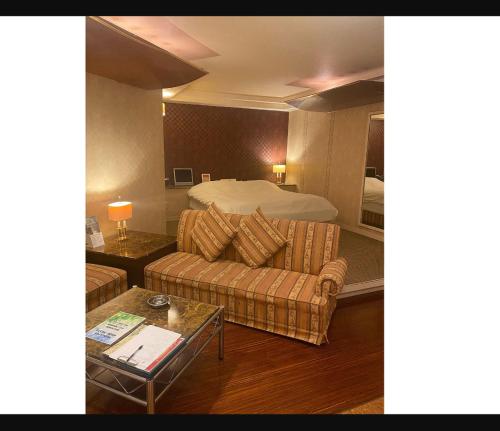 Habitación de hotel con cama y sofá en ラフォーレ, en Ichihara