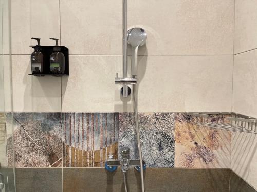 a shower with a shower head in a bathroom at 水蛙春 in Hengchun South Gate