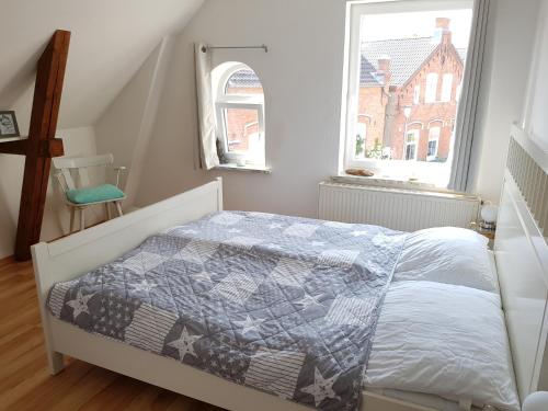 een slaapkamer met een bed met een quilt bij Muschelkästchen OG in Tönning
