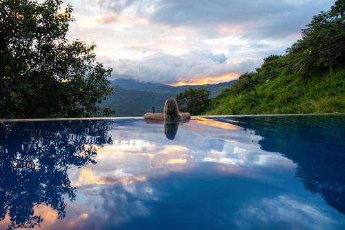 a woman in a infinity pool with a view of the mountains at Awesome Place in Ella