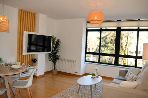 uma sala de estar com um sofá e uma mesa em A Xanela de Balneario em Mondariz-Balneario