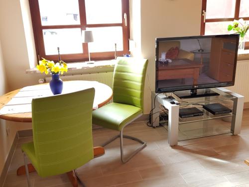 a living room with a table and a television at Backboord in Poppenbüll