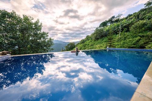 a pool with a reflection of the sky in the water at Awesome Place in Ella