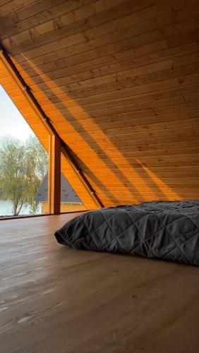 a bed in a room with a wooden ceiling at Lazni_Kyiv in Kyiv