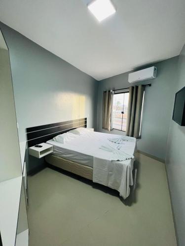 a bedroom with a bed in a room with a window at Pousada Ilha do Sol in Salinópolis