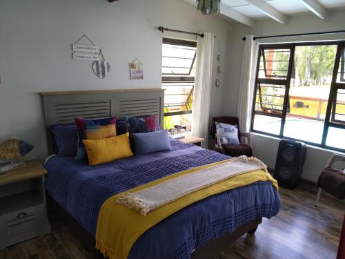 a bedroom with a bed with blue and yellow pillows at The Little Cove in Vaal Marina