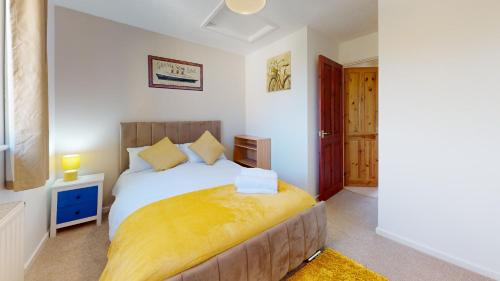 a bedroom with a large white bed with yellow sheets at Cosy 2 double bed property in Milton in Milton