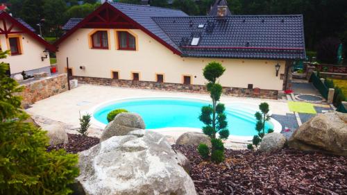 una casa con piscina en el patio en Zámeček Kaliště, en Poddubí