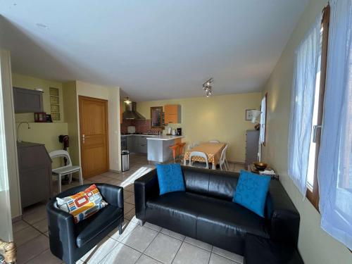 Il comprend un salon avec un canapé en cuir noir et une cuisine. dans l'établissement Maison spacieuse 8 pers avec terrasse - St-Chaffrey-S.Chevalier - FR-1-330E-134, à Saint-Chaffrey