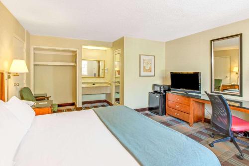 a hotel room with a bed and a flat screen tv at Travelodge by Wyndham Silver Spring in Silver Spring