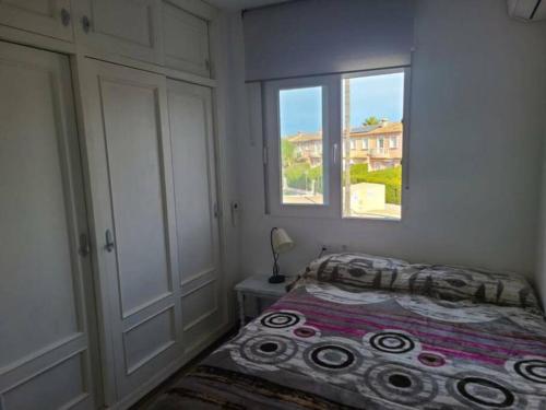埃爾斯波夫萊特斯的住宿－Casa Sofia in Els Poblets，一间卧室设有一张床和一个窗口