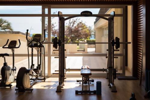 a gym with several exercise equipment in front of a window at Hotel Palas in Petrovac na Moru