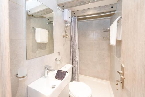 een witte badkamer met een wastafel en een toilet bij Casa Trenta Otto-J in Corfu-stad