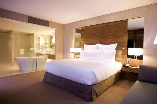 a bedroom with a large white bed and a bathroom at Hilton Brisbane in Brisbane