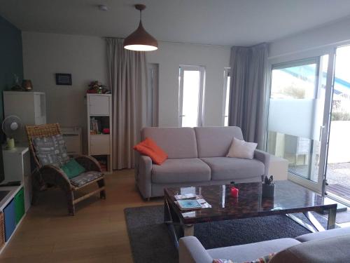a living room with a couch and a table at Duin en zee in Bredene