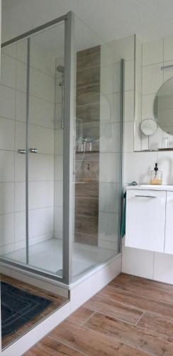 a glass shower in a bathroom with a sink at Ferienappartement Albschätzle in Bronnen