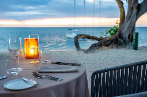 a table with a candle and glasses on the beach at Hilton Mauritius Resort & Spa in Flic-en-Flac