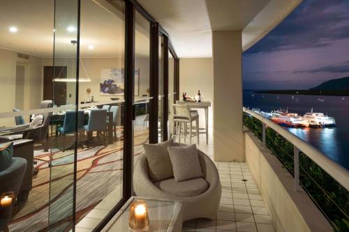 a room with a balcony with a view of the water at Hilton Cairns in Cairns